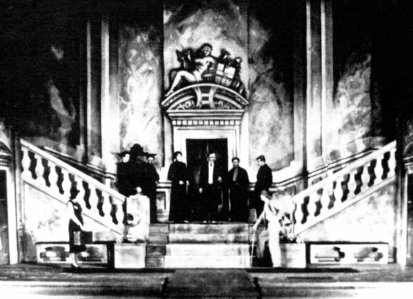 A small group of people at center; grand staircases lead off to left and right